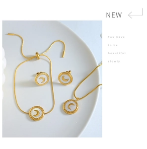 Detail of gold moon jewelry set with white mother of pearl on a white display plate