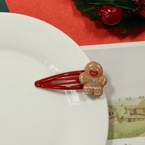 Close-up of red metal BB hair clip featuring a cute brown resin gingerbread man detail