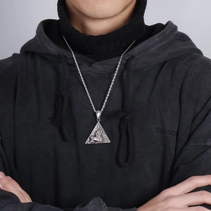 Detail of silver pyramid lion pendant on twist chain necklace shown on a male model
