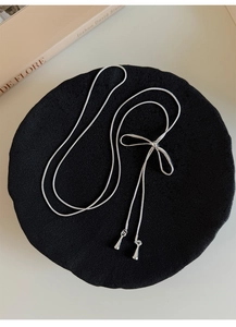 Dettaglio della collana a catena serpente d'argento con fiocco su velluto nero