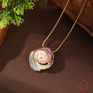 Golden snail pendant necklace with colorful enamel and pearl inlay on a snake chain