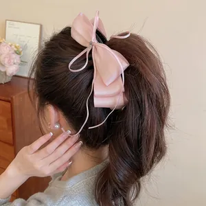 Pink satin bow hair clip with sparkling zircon rhinestones shown on high ponytail hairstyle