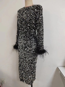 Détail de robe à paillettes avec garniture de plumes d'autruche noires sur les manches
