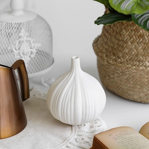 Vaso in ceramica bianca opaca a forma di aglio con strisce verticali per decorazione casa