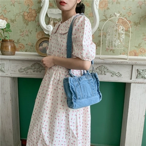 Retro washed denim crossbody bag shown on a model in a vintage interior setting
