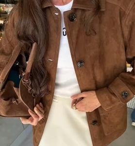 Close-up of brown suede jacket texture with lapel collar and single-breasted buttons