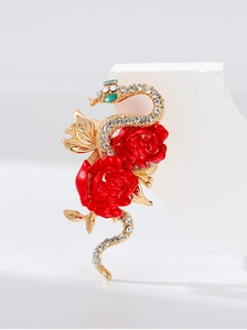 Detailed shot of a gold snake brooch with red roses and sparkling crystal rhinestones
