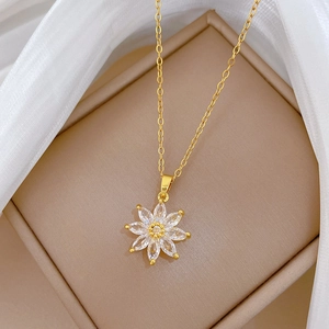 Detail of gold sunflower pendant with sparkling crystals on silk in a jewelry box