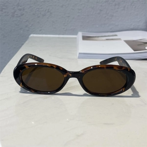 Detail view of retro oval sunglasses with brown tortoise frame on a marble surface