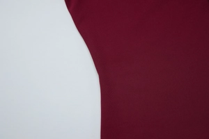 Détail de la maille côtelée bordeaux montrant la texture douce et les coutures