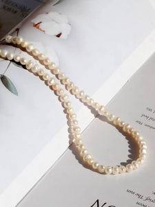Close-up of elegant freshwater pearl necklace resting on a vintage book page