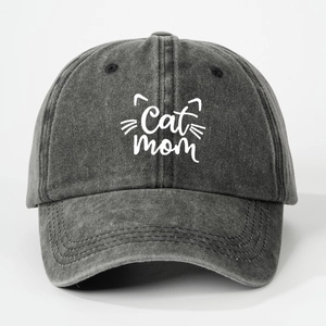 Front view of washed dark grey denim baseball cap with white Cat Mom embroidery