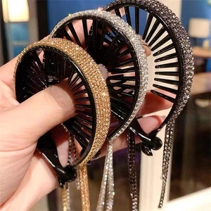 Detail view of gold and silver rhinestone tassel hair clips for elegant bun styling