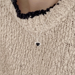 Close-up of a 925 silver heart necklace with black onyx pendant worn on a cozy sweater