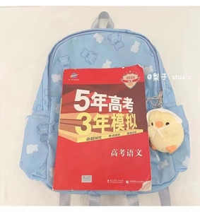 Detail of light blue cloud pattern backpack with a cute chick plush keychain accessory