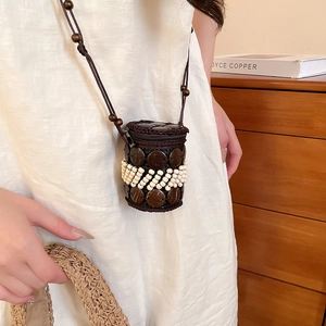 Detail of bohemian mini cylindrical crossbody bag with coconut shell beads and woven textures