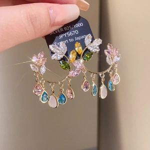 Detailed view of bohemian gold earrings with colorful zircon tassels and 925 silver tag