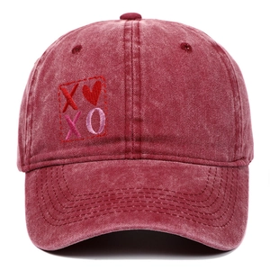 Vista frontale dettagliata del cappellino da baseball rosso con ricamo XOXO e cuore