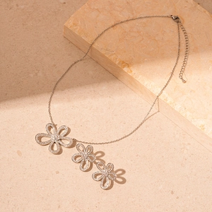 Elegant silver necklace featuring hollow zircon flower pendants on a stone tray