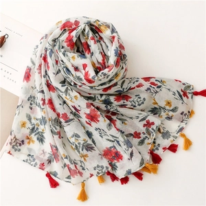 Close-up of floral print scarf with soft texture and vibrant red and yellow tassels