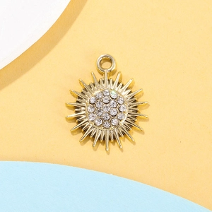 Detail of a golden sun pendant set with sparkling rhinestones for jewelry making