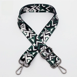 Close-up of geometric jacquard woven strap with gunmetal swivel hooks and adjustable buckle