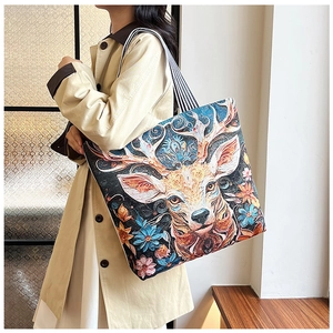 Detailed embroidery of colorful deer head and floral patterns on ethnic canvas tote bag