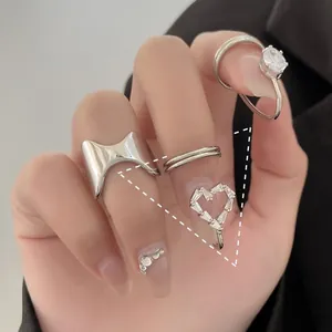 Close-up of sparkling zircon nail rings set in silver finish on hand with black suit