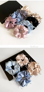 Detail of satin scrunchies with ribbons in pink, blue, and champagne colors