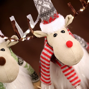 Close-up of plush Christmas reindeer with LED light-up antlers and red striped scarf