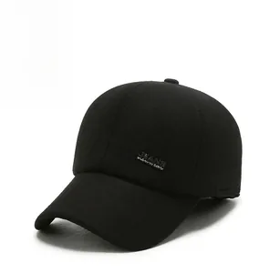 Detailed view of black wool baseball cap with metal logo plate and ear protection flaps
