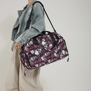 Large travel duffel bag with skull and rose print featuring adjustable shoulder strap