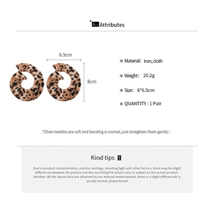 Detail showing leopard print fabric spiral hoop earrings with dimensions and iron material specs