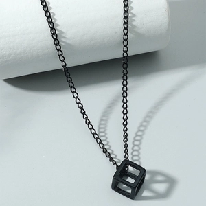 Minimalist black hollow cube pendant necklace on a sleek white display stand