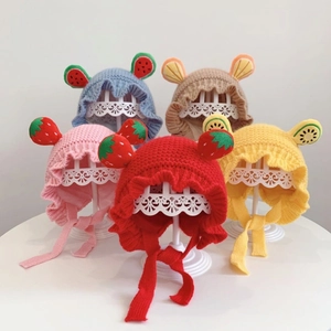 Detailed view of knitted baby hats with fruit-themed ears in multiple bright colors