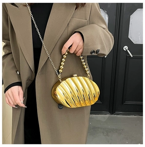 Detailed view of golden shell acrylic evening bag with beaded handle and chain strap
