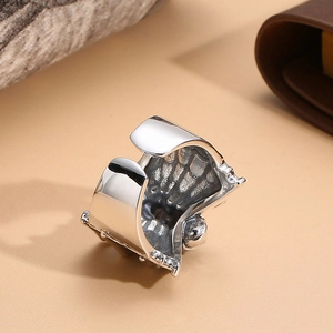 Macro shot of silver punk spider ring showing wide metal band with inner texture