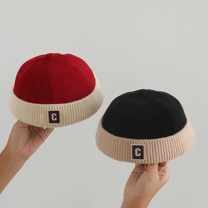 Close-up of knit dockers cap showing vertical ribbed texture and leather 'C' patch