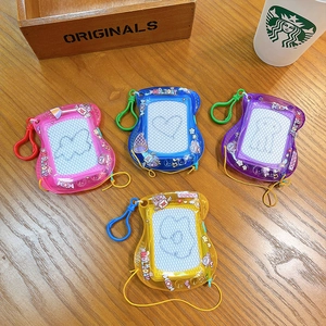 Mini magnetic drawing boards in four pastel colors with keychain hooks on wooden desk