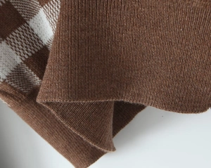 Macro view of brown and white checkered knit fabric with ribbed texture for cardigan set