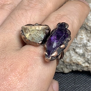Detail of vintage copper ring with raw yellow and purple amethyst stones on hand