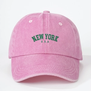 Detailed embroidery of NEW YORK USA on a pink washed cotton baseball cap with retro texture