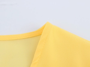 Detail shot of yellow lace stitching and high-quality chiffon seam on V-neck dress
