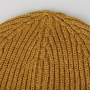 Close-up of mustard yellow ribbed knit beanie showing high-quality stitching detail