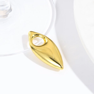 Macro view of a teardrop-shaped gold metal pendant with a smooth mirror finish for DIY jewelry