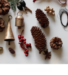 Close-up of rustic Christmas ornaments with pine cones, vintage bells and red berries