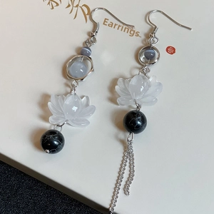 Detail of asymmetric lotus petal earrings with pearl tassels and silver hooks