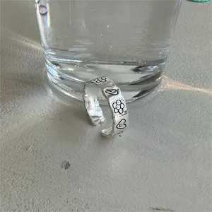 Detail of S925 sterling silver ring with black enamel flowers, hearts and smiley faces