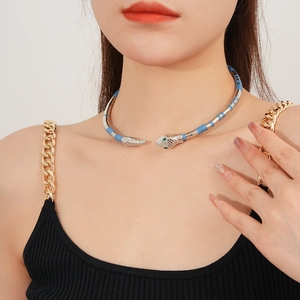 Close-up of a layered snake-shaped choker necklace with green eyes and blue accents