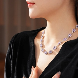 Detail of luxury necklace with purple teardrop gemstone and small diamonds on silver chain